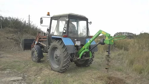 Трактор МТЗ 80 с земляным буром Flagman в работе