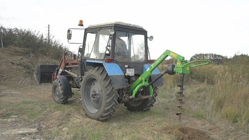 Трактор МТЗ 80 с земляным буром Flagman в работе