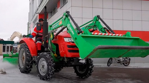 Трактор Shifeng 254 с фронтальным погрузчиком и щеткой Kerland в работе